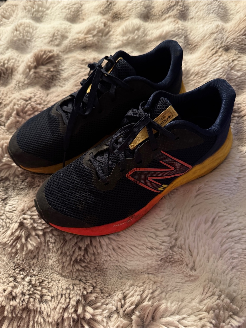 New Balance Youth Navy Running Shoes with Orange and Yellow Accents